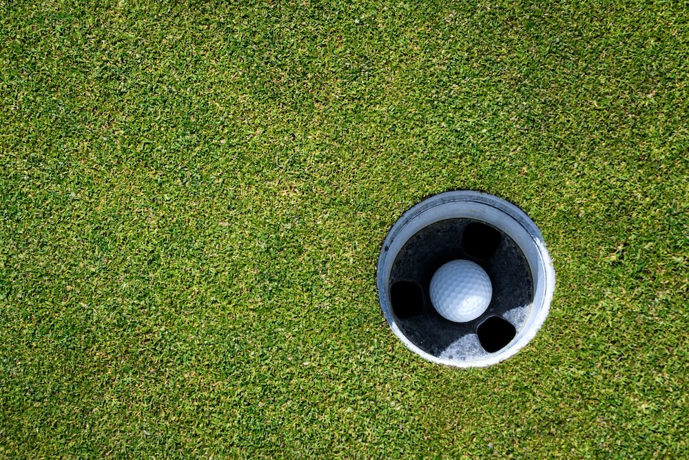 Golf ball in hole close up shot