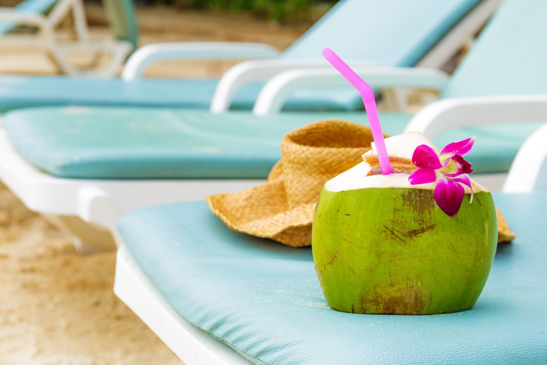 beach lounge chair, sun hat, and coconut drink
