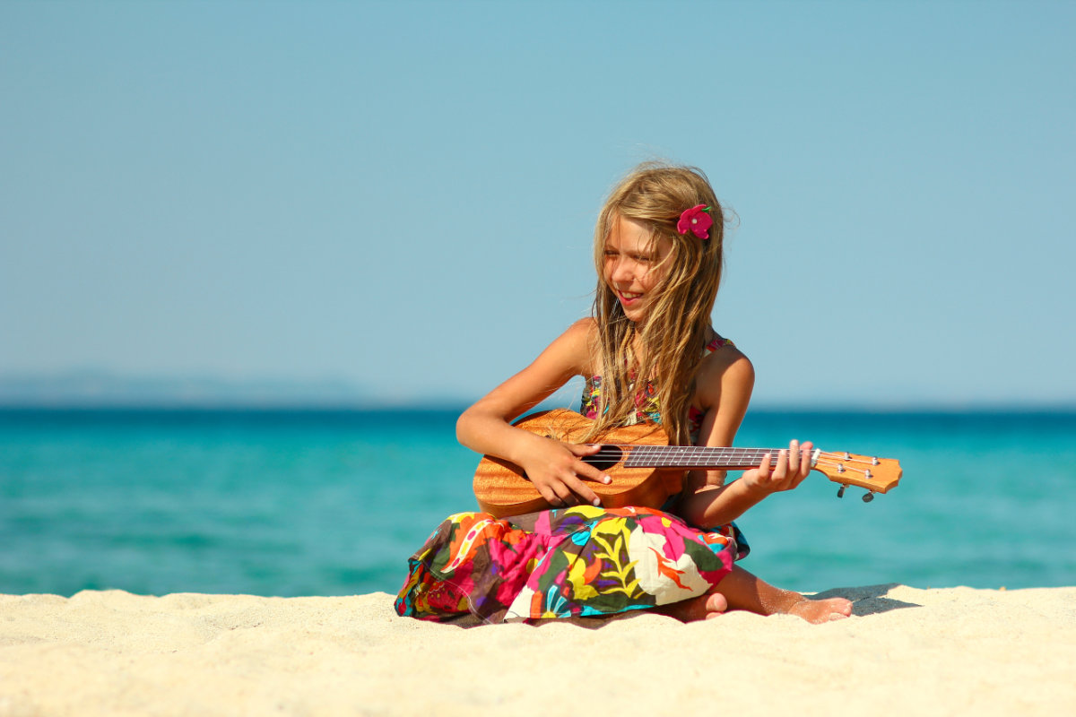little girl on Hawaiian beach with ukulele summer