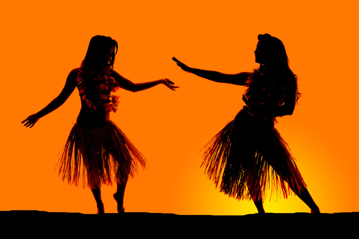 silhouette of Hawaiian woman grass skirts dancing luau
